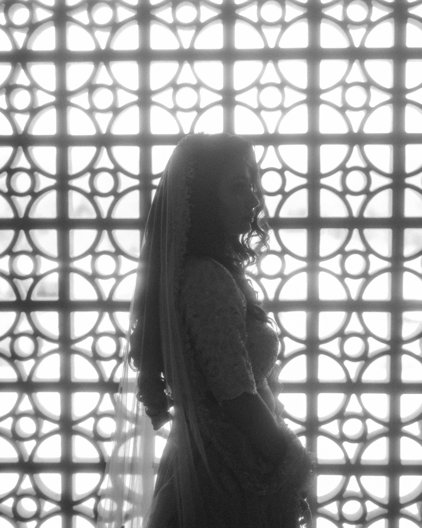 Artistic silhouette of bride against decorative jaali screen